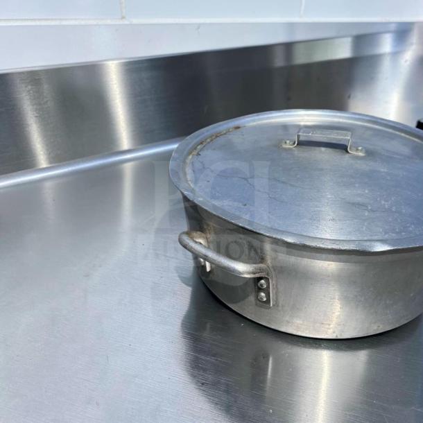Heavy-duty commercial aluminum stock pot with lid. Superior condition, large capacity, suitable for restaurant use. Model: GEN-S-POT-0897.