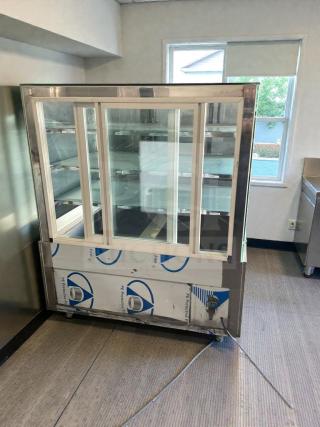 Immaculate commercial refrigerated glass display case, 115V/single phase; fully tested, protective film partially intact.