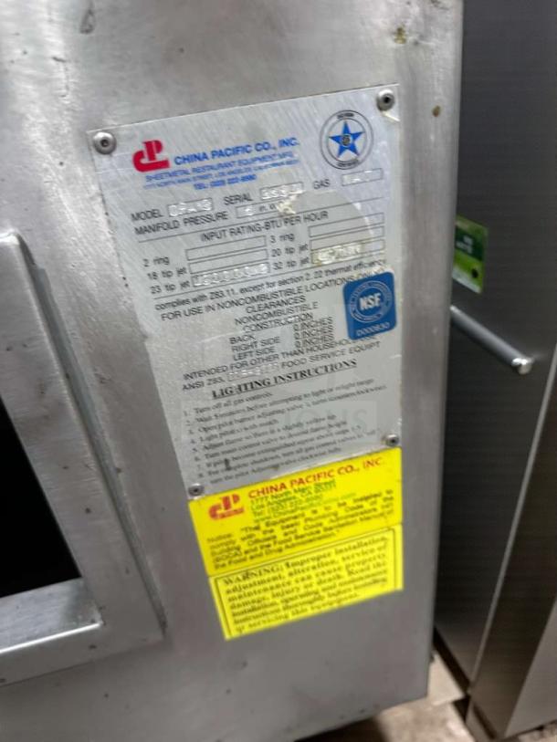 China Pacific Commercial Gas Wok Range tag showing brand, model CP-L-RNG-0320, NSF certification, and usage instructions.