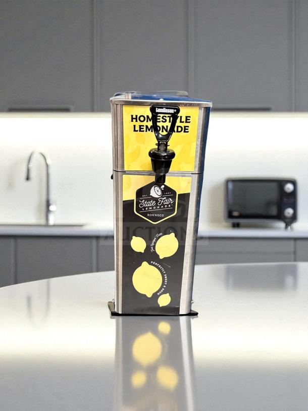 Newco FPM-1 beverage dispenser for lemonade, featuring stainless steel design, "State Fair" branding, tested and NSF listed.