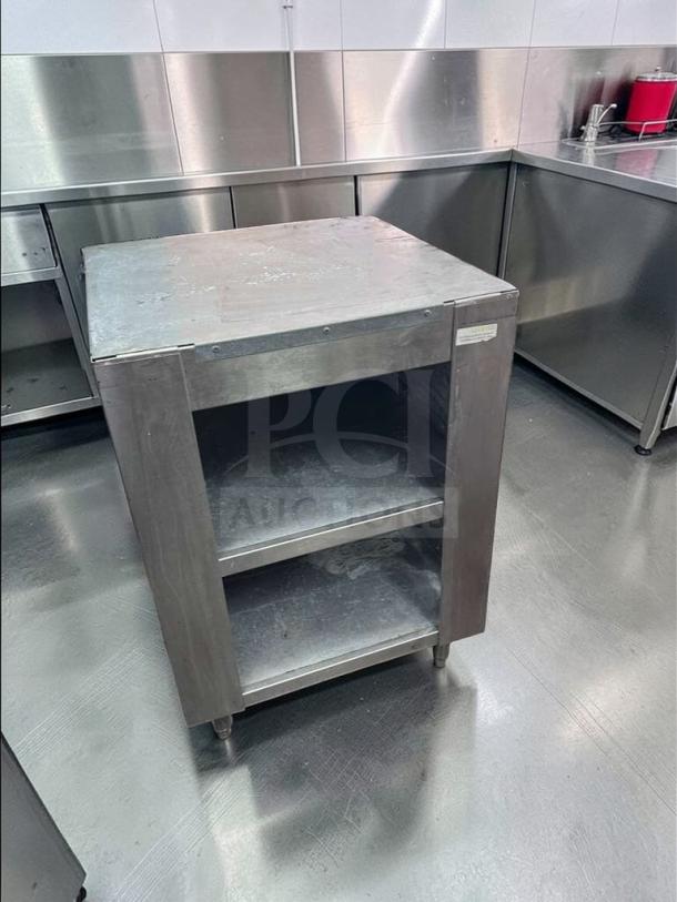 Commercial stainless steel equipment stand, excellent condition, with two open shelves for storage, model COM-S-STD-0687.