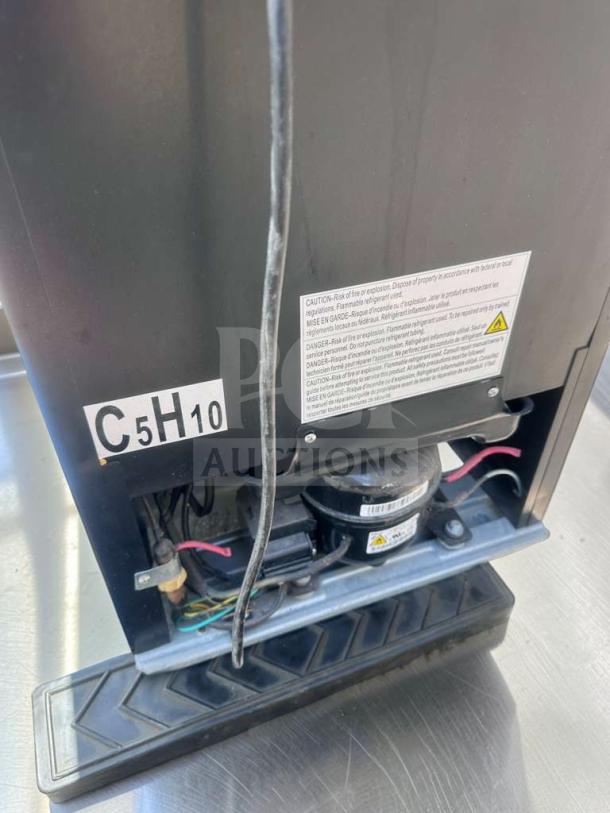 Rear view of Danby DBC120BLS-3 3.5 Cu. Ft. Beverage Center, showing compressor, wires, and caution label.