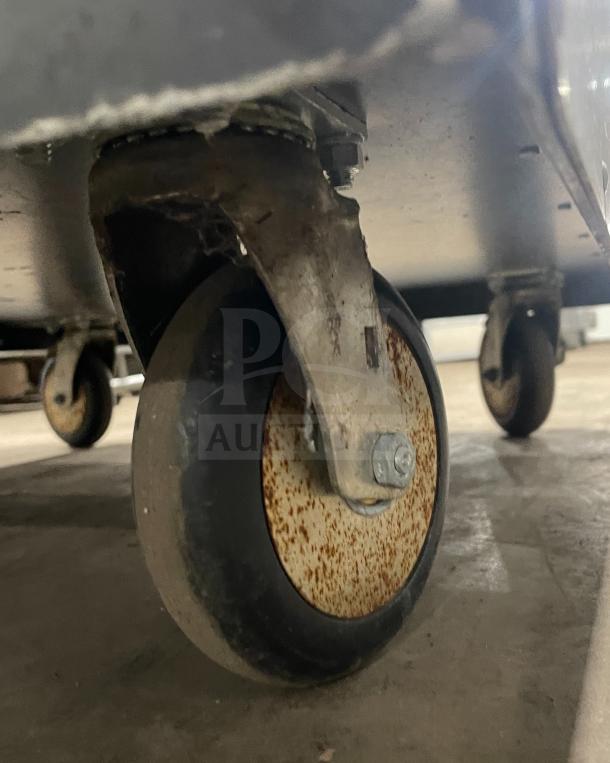 Stainless steel heated holding cabinet, Metro C200N model on casters, shows signs of rust, features digital controls, holding racks.