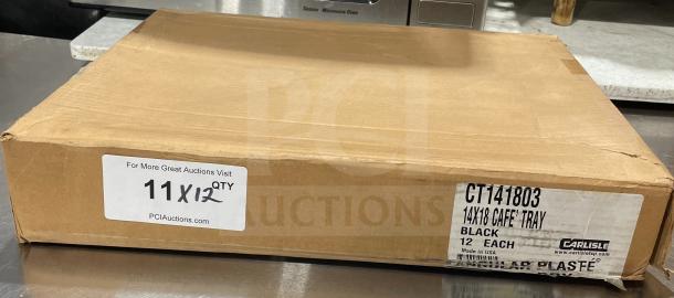 Box of 12 Carlisle NCT1418 black trays, 14"x18", brand new. Labels show model, size, and made in USA.
