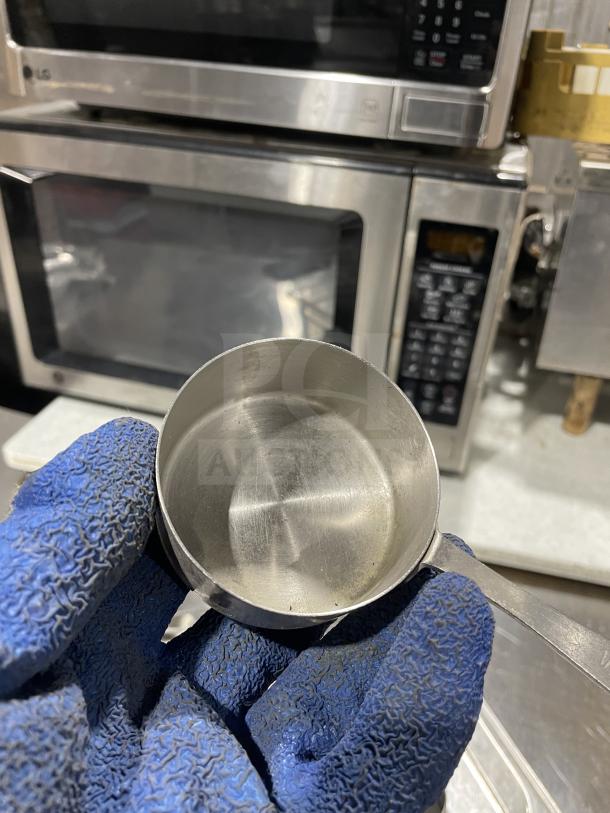 Commercial stainless steel measuring cup, durable design. Appears lightly used, showcasing a shiny finish, no visible markings.