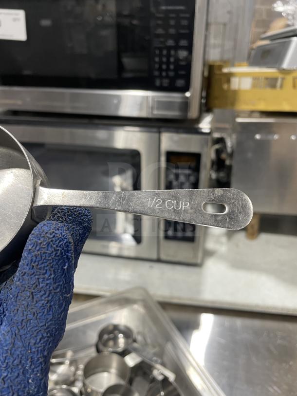 Stainless steel measuring cup, 1/2 cup size, engraved marking, excellent condition, durable commercial quality.