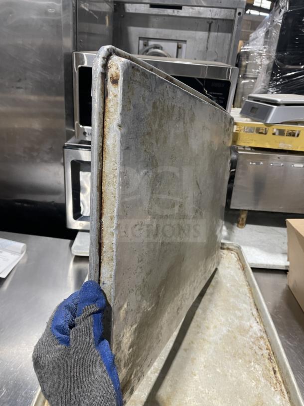 Stainless steel baking sheet set by Focus Food Service, showing wear and patina, 11 pieces included, auction item.