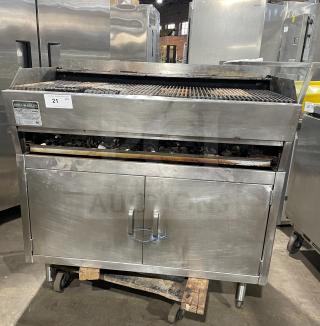 Rankin Delux stainless steel countertop char broiler grill, natural gas-powered, features back and side splashes, on legs, visible wear.