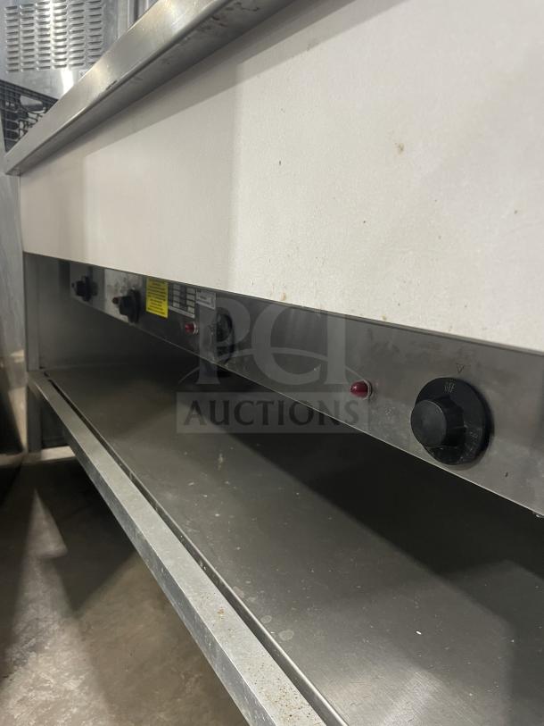 Atlas stainless steel 4-well hot food steamtable, electric-powered, model WIH-D&M-4, with sneeze guard, tray slide, and storage base.