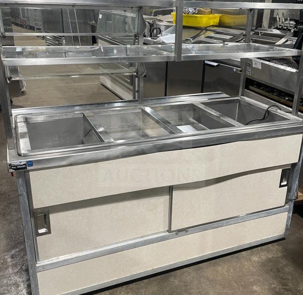 Atlas Metal Industries stainless steel hot food steam table, model WCM-BT-4. Features four wells, sneeze guard, and storage cabinet.