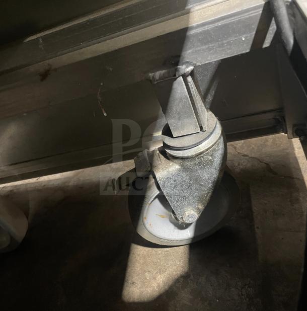 Atlas Metal Industries commercial hot food table caster detail. Model WCM-BT-4, stainless steel, 4 wells, on wheels.