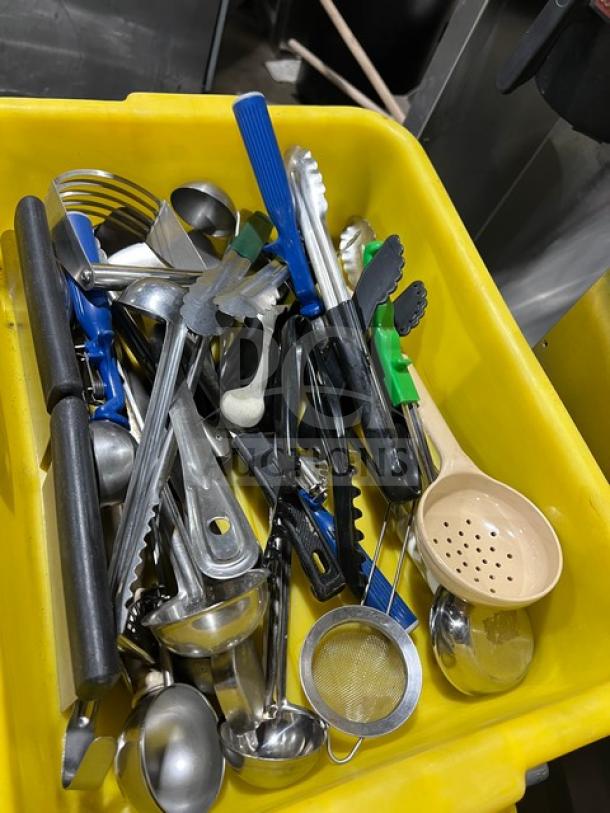 Assorted Winco TR34W kitchen hand tools in a yellow bin; includes tongs, ladles, strainer, in used condition.