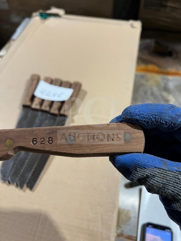 Dexter Russell stainless steel bread knife, Model 628, with wooden grip handle. Features engraved markings. Good condition.