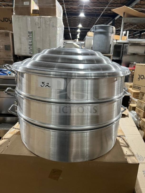 New commercial stainless steel food steamer with 3 tiers, polished finish, like new condition, resting on a cardboard box.