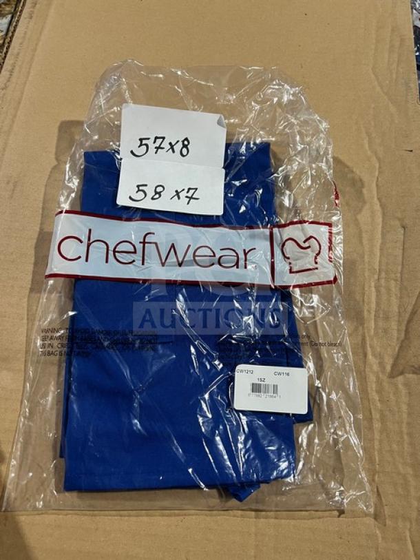 Chefwear blue apron, model 1SZ, in original packaging. One size fits all. New condition. Marked "57x8" and "58x7."
