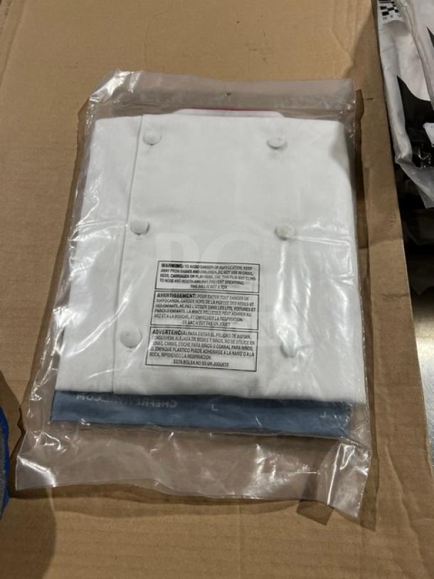 Chef Revival white jacket with red piping, size M, model J008RD-S, new in packaging with safety label visible.