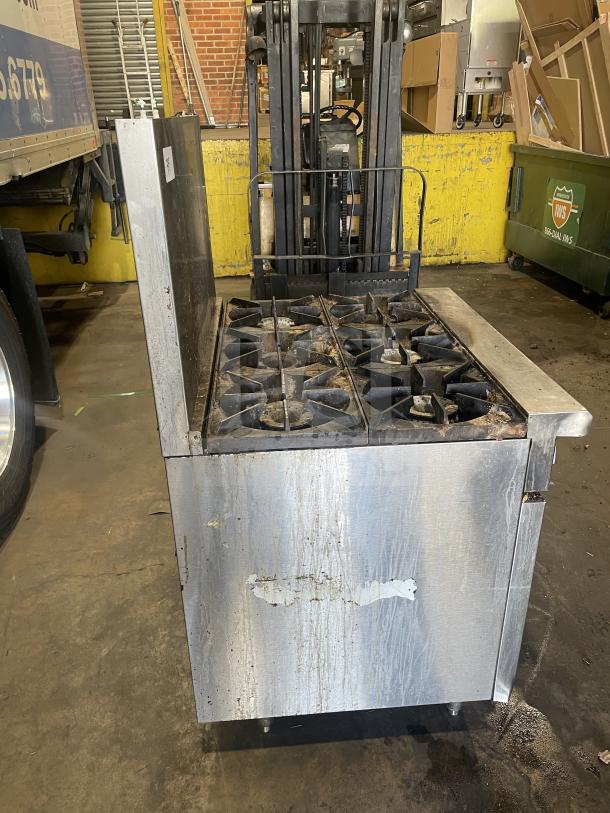 Royal commercial stainless steel 6-burner gas range/oven combo with backsplash, overhead salamander shelf, and wired oven rack. Used condition.