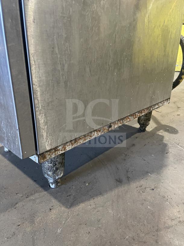 Royal stainless steel natural gas deep fat fryer with back splash, includes 1 frying basket, on rusted casters.