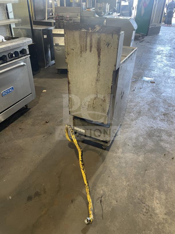 Royal commercial stainless steel natural gas deep fat fryer with back splash, one frying basket, on casters. Used condition.