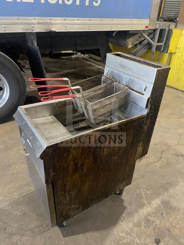 Pitco Frialator commercial stainless steel natural gas fryer with backsplash, basket hanger, and fry basket on legs.