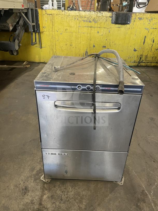 Comenda stainless steel undercounter dishwasher, commercial series, SN: GS0018690315. Features hoses, some exterior wear.