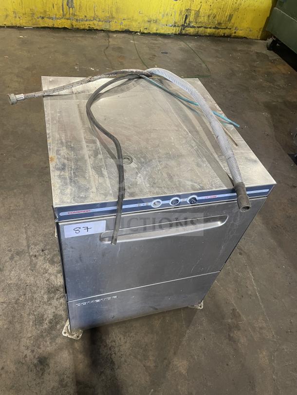 Comenda Stainless Steel Undercounter Commercial Dishwasher, Serial Number GS0018690315, in used condition with hoses attached.