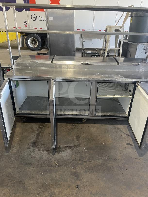 True TTP-93 stainless steel 3-door refrigerated pizza prep table on casters, open doors, good condition, commercial use.