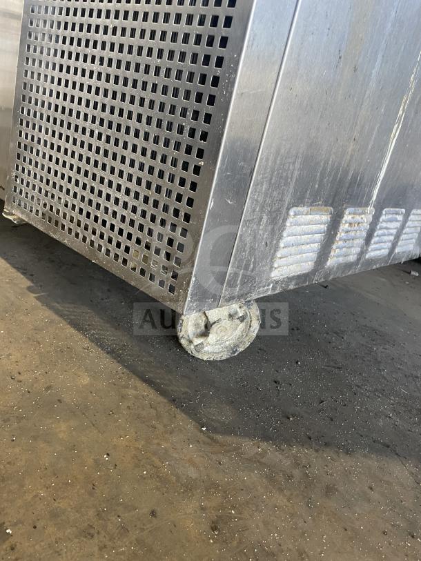 True TTP-93 refrigerated pizza prep table, stainless steel, three doors, on casters, 115V, showing caster detail.