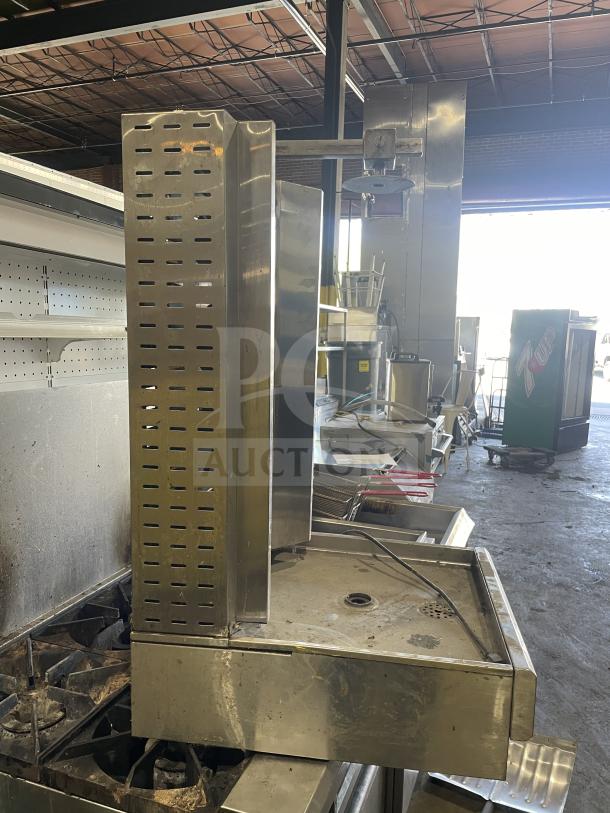 Commercial gas-powered vertical broiler with 4 burners, stainless steel, used condition, ideal for high-volume cooking.