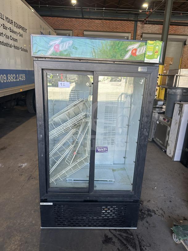 Universal MC1100S-1-SU-64 commercial beverage cooler with 2 sliding glass doors, 7UP branding, and serial number 3409S21496.