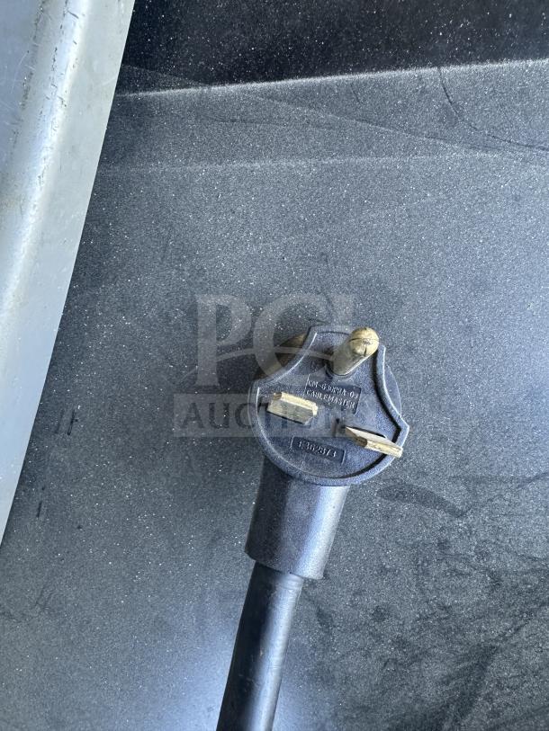 Close-up of TurboChef commercial oven power plug on gray countertop surface. Electric cable with three-prong configuration.