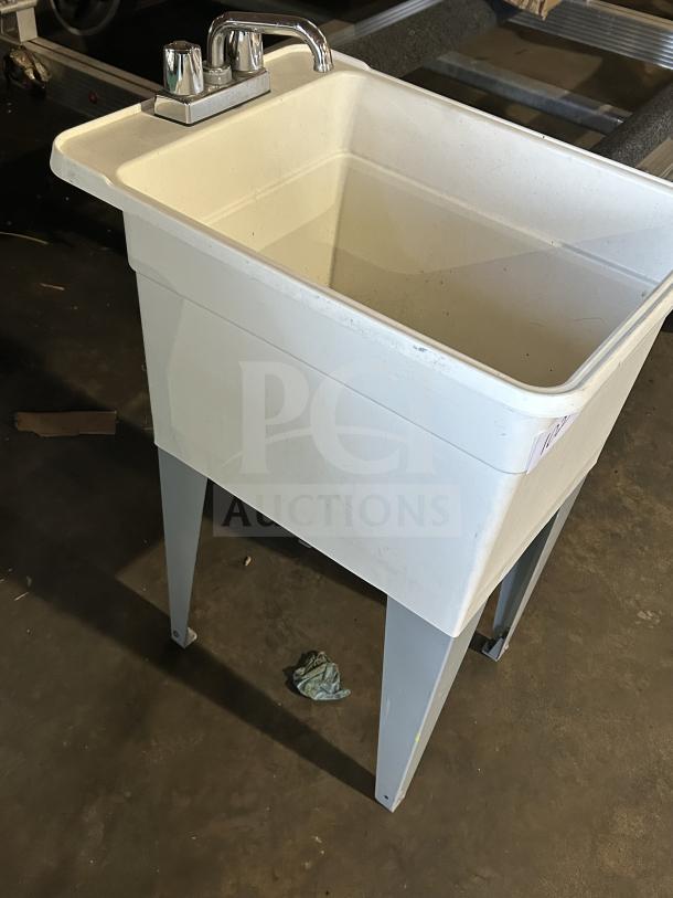 Good Mustee Liltub commercial single laundry tub with two-handle faucet, on metal legs, in used condition.