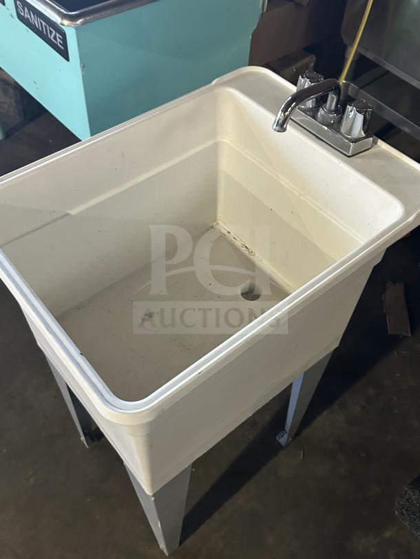 Mustee Liltub commercial laundry tub with two-handle faucet, white, on sturdy legs, in good condition.