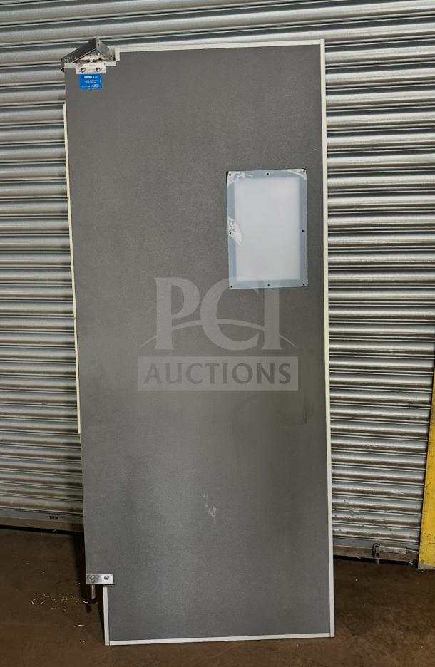 Impacdor refrigerator door in good condition, SN: 830160, features a small window and corner hardware. Suitable for replacement or repair.