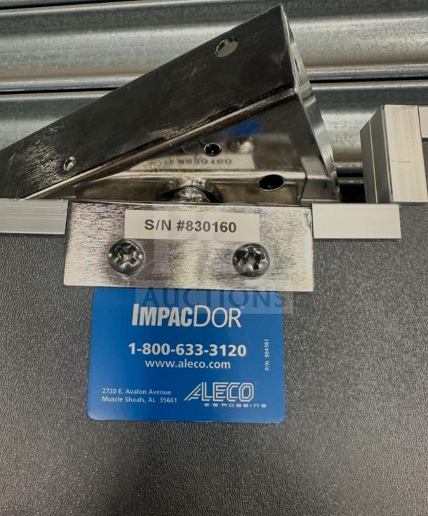 Impacdor refrigerator door with serial number 830160, metal hinge detail, and blue identification label.
