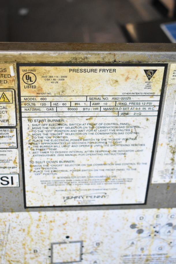 2025 Henny Penny 600 Pressure Fryer, natural gas, 80,000 BTU, on casters. Model 600 info plate visible, UL listed. Used condition.