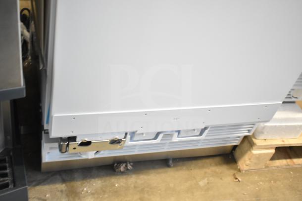 Brand new single door reach-in cooler, 115 volts, 1 phase, minor scratches, and dents visible.