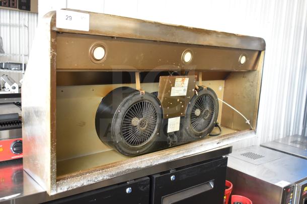 Vintage range hood with dual exhaust fans, visible wear, integrated lights, and manufacturer labels. Perfect for restoration.