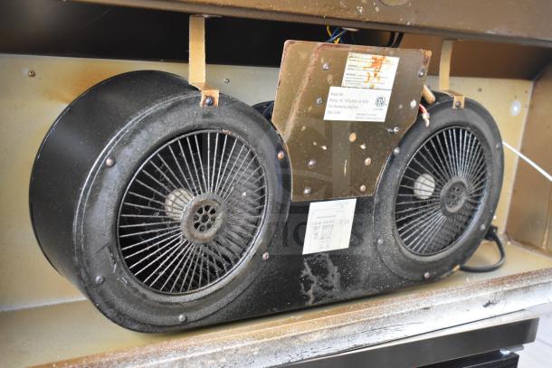 Vintage range hood with dual fan system, metal casing, visible wear and rust. Features labeled with model and specifications.