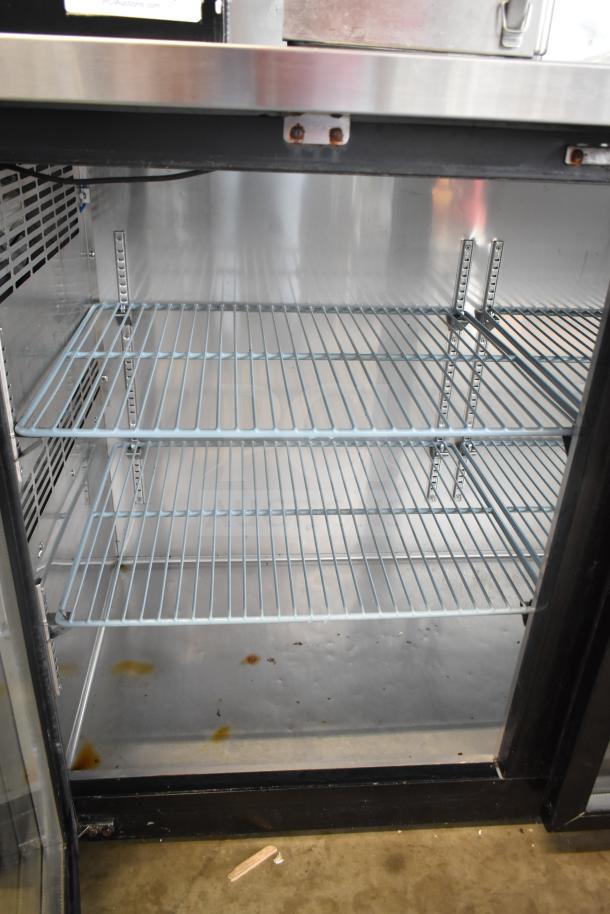 BRAND NEW EQ UBB-24-60G commercial back bar cabinet with 2 glass doors, showing interior wire shelves. 115V, 1 phase. Scratch and dent condition.