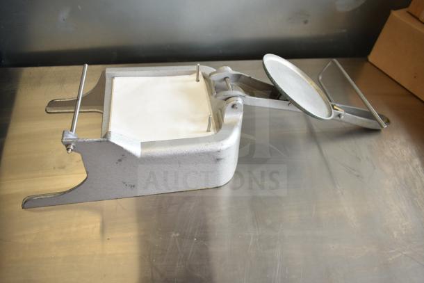 Patty former on metal surface, includes stainless steel drop-in bins. Good condition, minor wear visible.