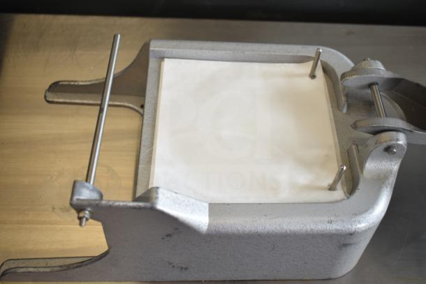 Patty former with metal frame, adjustable rods, and paper insert; part of a lot including stainless steel drop-in bins.