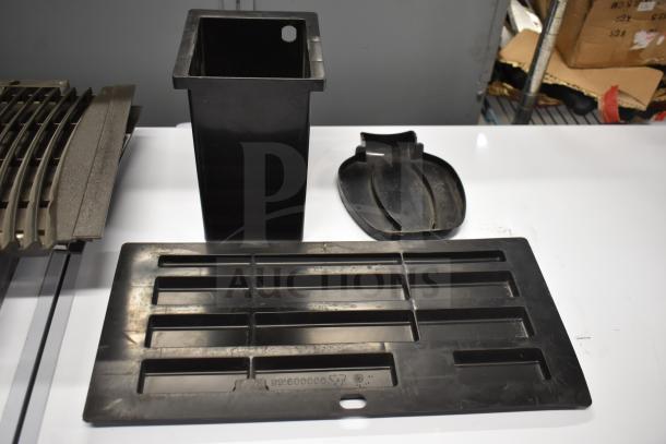 Eight assorted items including a cooler kick plate and ice machine head screen piece, in used condition. Black plastic components.
