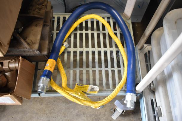 Bundle of 32 items, including range grates and a gas hose. Blue and yellow hose with visible labels indicating specifications.