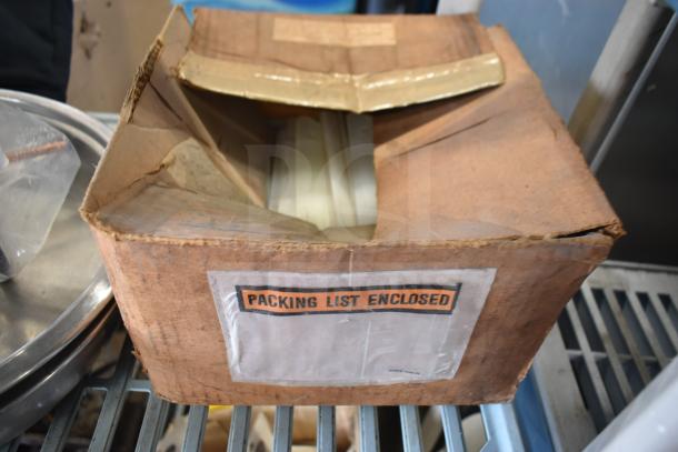 Box with label "Packing List Enclosed," containing portafilters, condensate loop, and poly pieces for ice cream machine.