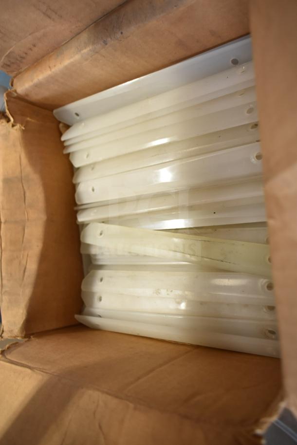 Box of poly pieces for ice cream machine, multiple white items, slight wear visible.