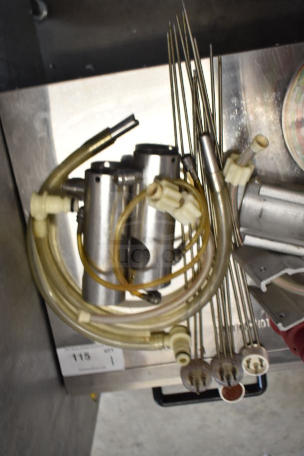 92 various ice cream machine parts, including metal handles and hoses, in good condition. Lot number 115 visible.