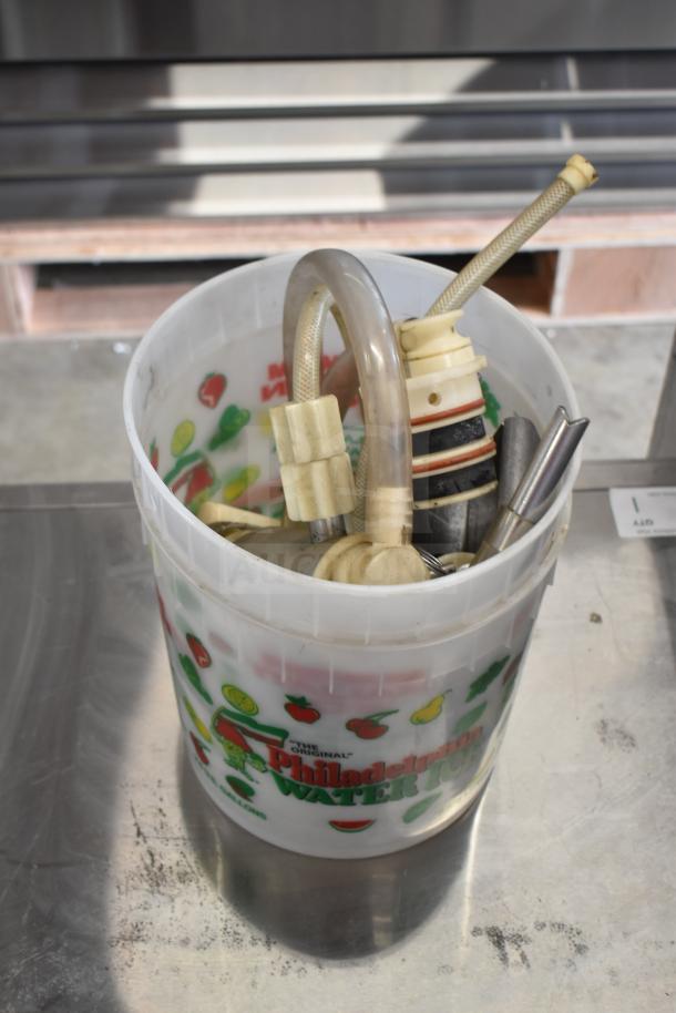 Bucket containing various ice cream machine parts, including handles and hoses, labeled "Philadelphia Water Ice." Condition varies.