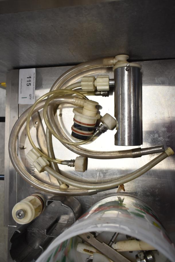 Assorted ice cream machine parts, including handles and hoses, in used condition. Auction lot tag visible.