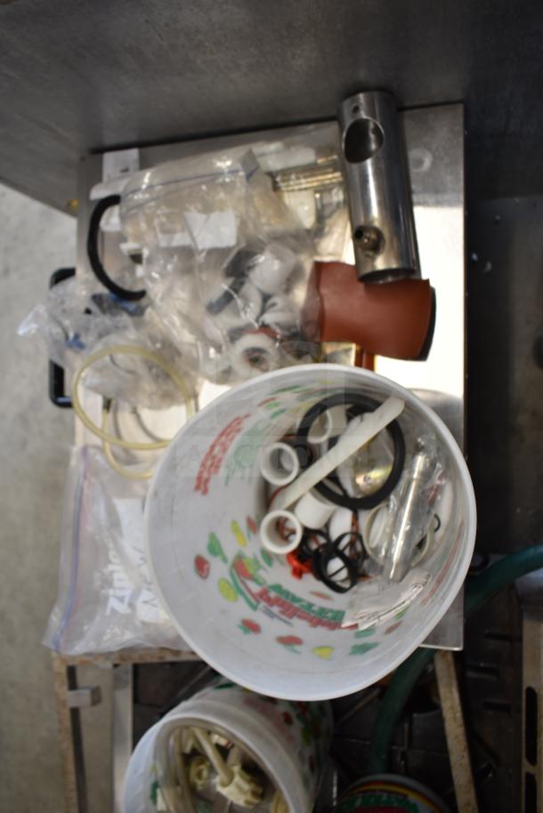Cluster of 92 diverse ice cream machine parts, including handles. Various materials, organized in containers, suitable for replacement or repair.